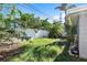 Backyard with overgrown grass and a white fence at 4019 Helena Ne St, St Petersburg, FL 33703