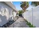 Side yard with a concrete pathway and white fence at 4019 Helena Ne St, St Petersburg, FL 33703