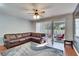 Living room with sectional sofa, sliding doors to patio, hardwood floors and ceiling fan at 4950 Pond Ridge Dr, Riverview, FL 33578