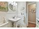 Small bathroom with pedestal sink, white wainscoting, and linen towel at 7318 Filbert Ln, Tampa, FL 33637