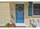 Close-up of charming blue front door with wreath and white bench at 7318 Filbert Ln, Tampa, FL 33637