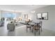 Living room with gray sofa, glass dining table, and water views at 7902 Sailboat Key S Blvd # 405, South Pasadena, FL 33707