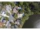 Aerial view of homes near a lake; one property features a pool at 203 Whisper Lake Rd, Palm Harbor, FL 34683