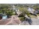 Aerial view of a house near a lake with a pool and lush landscaping at 203 Whisper Lake Rd, Palm Harbor, FL 34683