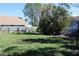 Large grassy backyard with mature trees and wooden fence at 215 176Th Terrace E Dr, Redington Shores, FL 33708
