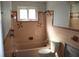 Retro bathroom with pink tile and a bathtub shower combo at 215 176Th Terrace E Dr, Redington Shores, FL 33708