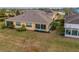 Backyard view of house with sunroom and landscaped yard at 2311 Nottingham Greens Dr # 2311, Sun City Center, FL 33573