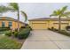 Two-car garage, landscaping, and a yellow exterior at 2311 Nottingham Greens Dr # 2311, Sun City Center, FL 33573