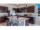Modern kitchen with dark cabinetry, granite countertops, and stainless steel appliances at 32619 Turtle Grace Loop, Wesley Chapel, FL 33545