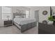 Bright bedroom with a gray upholstered bed, nightstands, and carpeted floor at 3281 Suncoast Plains Dr, Odessa, FL 33556