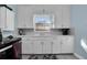 Bright kitchen with white cabinets, modern stove, and refrigerator at 4825 Dr Martin Luther King Jr S St, St Petersburg, FL 33705