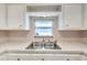 Bright kitchen features white cabinets, double sink, and an electric range at 4851 W Gandy Blvd # B6 L3, Tampa, FL 33611