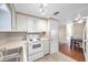 White kitchen appliances and cabinets, view into dining area at 4851 W Gandy Blvd # B6 L3, Tampa, FL 33611