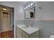 Bathroom with gray and pink tile, vanity, and a mirror at 6056 2Nd N Ave, St Petersburg, FL 33710