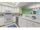 White kitchen features stainless steel appliances and a view into the living area at 700 Island Way # 704, Clearwater Beach, FL 33767
