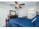 Bedroom with ceiling fan, dresser, and blue bedding at 7014 King Creek Dr, Sun City Center, FL 33573