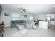 Open concept living room with gray sectional sofa, large TV, and ceiling fan at 7014 King Creek Dr, Sun City Center, FL 33573