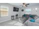 Comfortable living room with gray sectional, ottoman, and large windows at 7014 King Creek Dr, Sun City Center, FL 33573