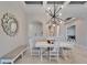 Bright dining room with white table, bench, and modern chandelier at 9152 Warm Springs Cir, Parrish, FL 34219