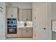 Well-equipped kitchen with gray cabinets and built-in double oven at 9152 Warm Springs Cir, Parrish, FL 34219