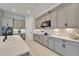 Modern kitchen with gray cabinets, white quartz countertops, and a farmhouse sink at 9152 Warm Springs Cir, Parrish, FL 34219