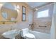 Clean bathroom with a bathtub, shower, pedestal sink, and tiled walls at 9156 142Nd St, Seminole, FL 33776