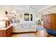 Bright bedroom with a king-size bed, wooden dresser, and ceiling fan at 1013 Lake Avoca Ct, Tarpon Springs, FL 34689