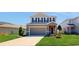 Two-story house with a neutral color scheme and a well-manicured lawn at 10827 High Noon Trl, Parrish, FL 34219