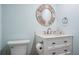 Updated bathroom with white vanity, round mirror, and neutral decor at 1230 Gulf Blvd # 604, Clearwater Beach, FL 33767