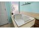 Soaking tub with window and tiled surround at 12509 Safari Ln, Riverview, FL 33579