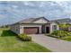 Attractive single-story home with a brown garage door and landscaped front yard at 12626 Tahitian Pearl Cir, Parrish, FL 34219