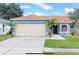 Cute blue house with a two-car garage and palm trees at 12908 Brant Tree Dr, Riverview, FL 33579