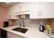 Well-lit kitchen featuring a stainless steel sink, white cabinets, and quartz countertops at 1330 70Th N St, St Petersburg, FL 33710