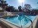 Large community pool with a sun-drenched deck area, palm trees, and a safety fence at 1330 70Th N St, St Petersburg, FL 33710