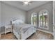 Bright bedroom with wood-look flooring, a ceiling fan, and plantation shutters at 13307 Fawn Lily Dr, Riverview, FL 33579