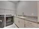 Laundry room with utility sink, cabinets and modern appliances at 13307 Fawn Lily Dr, Riverview, FL 33579