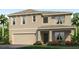 Two-story house with beige exterior, two-car garage, and landscaping at 1715 Tahitian Sunrise Dr, Plant City, FL 33565