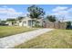 Newly renovated home with a gray exterior, landscaped yard, and modern fence at 175 83Rd N Ave, St Petersburg, FL 33702