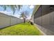Backyard with well-maintained lawn and white fence, adjacent to a screened-in lanai at 1838 Tallulah Ter, Wesley Chapel, FL 33543