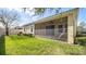 Exterior view of the screened-in lanai and green backyard of the home at 1838 Tallulah Ter, Wesley Chapel, FL 33543