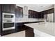Stylish kitchen showcasing stainless steel appliances, dark wood cabinets, and sleek backsplash, perfect for cooking at 1838 Tallulah Ter, Wesley Chapel, FL 33543
