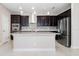 Modern kitchen featuring dark cabinetry, stainless steel appliances, and a spacious center island for food preparation at 1838 Tallulah Ter, Wesley Chapel, FL 33543