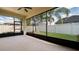 Enclosed lanai with a ceiling fan offers a serene view of the backyard's landscaping at 1838 Tallulah Ter, Wesley Chapel, FL 33543