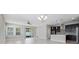 Open-concept living room featuring sliding glass doors, tile floors, and modern chandelier at 1838 Tallulah Ter, Wesley Chapel, FL 33543