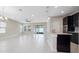 Bright open concept living area showcasing tile floors, a modern kitchen island and sliding doors to the backyard at 1838 Tallulah Ter, Wesley Chapel, FL 33543