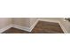 Close up on the wood flooring showcasing its dark brown color, grain, and white molding at 1838 Tallulah Ter, Wesley Chapel, FL 33543
