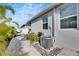 AC unit and paved backyard path with tropical plants at 2584 89Th Street E Cir, Palmetto, FL 34221