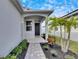 Front entry with covered porch, walkway, and tropical landscaping at 2584 89Th Street E Cir, Palmetto, FL 34221