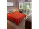 Bright bedroom with orange bedding and access to a sunroom at 2812 Miriam S St, Gulfport, FL 33711