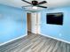 Bright bedroom with light blue walls and wood-look floors at 3148 Harvardston Loop, Holiday, FL 34691